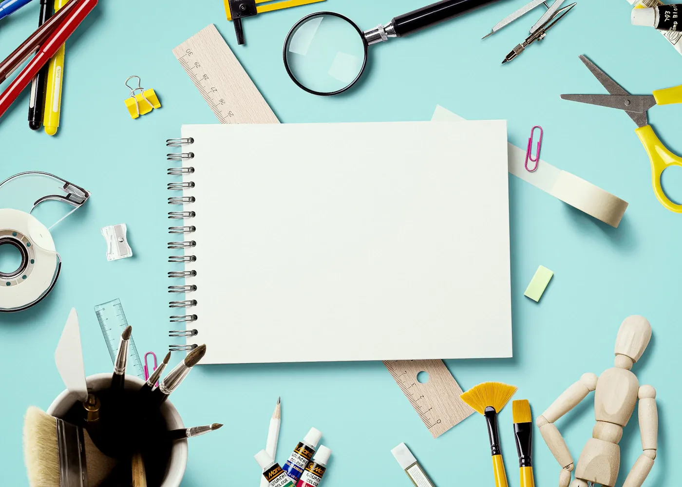 Libreta y material de escritorio sobre fondo claro · fotografía ilustrativa
